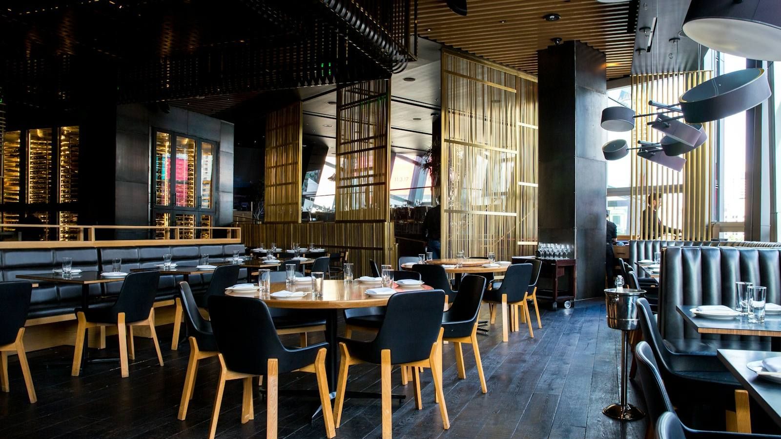Comedor de un restaurante moderno con mesas preparadas y luz cálida