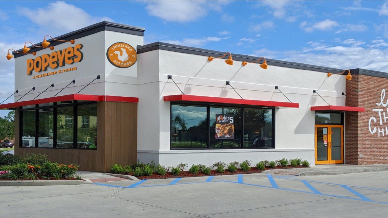 Fachada de un restaurante Popeyes con su rótulo y logotipo Louisiana Kitchen