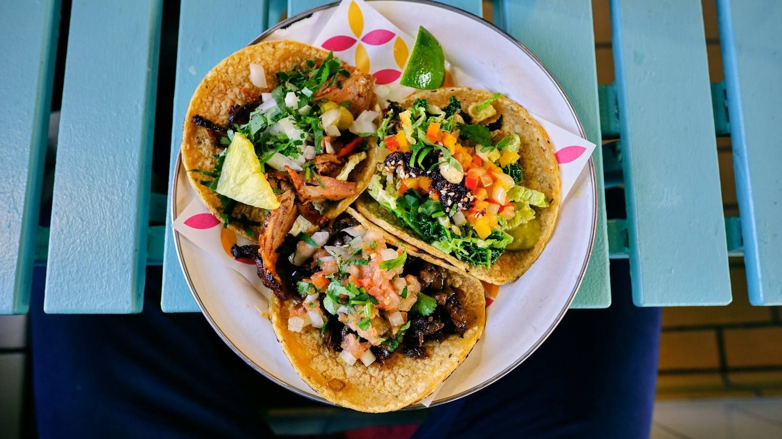 Plato de tacos con carne y verduras sobre una mesa azul